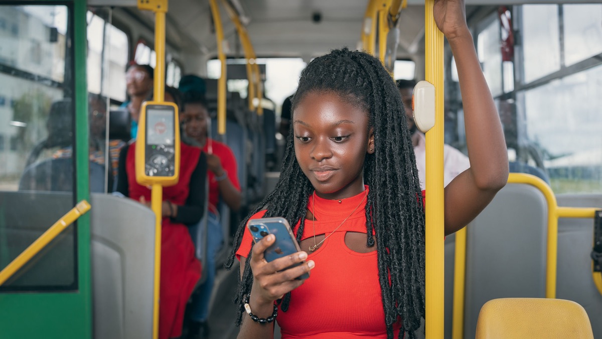 A young woman on a city bus looking at her phone